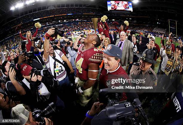 DeMarcus Walker and head coach Jimbo Fisher of the Florida State Seminoles celebrate their 33 to 32 win over the Michigan Wolverines during the...