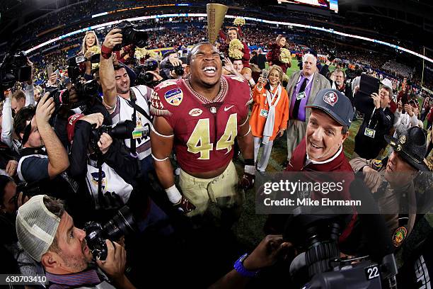 DeMarcus Walker and head coach Jimbo Fisher of the Florida State Seminoles celebrate their 33 to 32 win over the Michigan Wolverines during the...