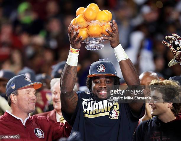 Dalvin Cook and head coach Jimbo Fisher of the Florida State Seminoles celebrate their 33 to 32 win over the Michigan Wolverines during the Capitol...