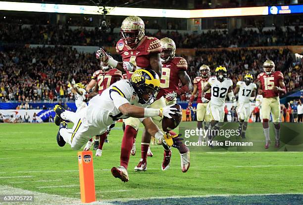 Chris Evans of the Michigan Wolverines runs for a 30-yard touchdown in the fourth quarter as Tarvarus McFadden of the Florida State Seminoles defends...