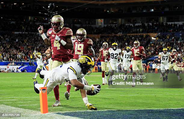 Chris Evans of the Michigan Wolverines runs for a 30-yard touchdown in the fourth quarter as Tarvarus McFadden of the Florida State Seminoles defends...