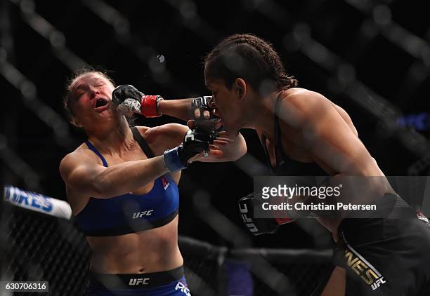 Amanda Nunes of Brazil punches Ronda Rousey in their UFC women's bantamweight championship bout during the UFC 207 event on December 30, 2016 in Las...