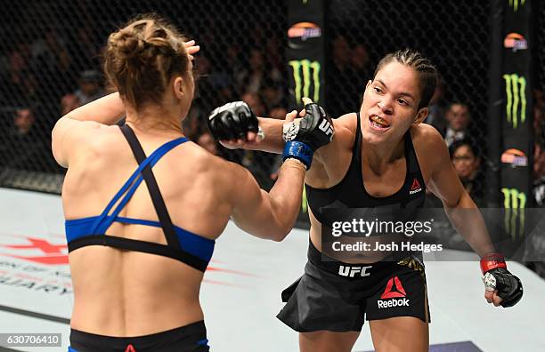 Amanda Nunes of Brazil punches Ronda Rousey in their UFC women's bantamweight championship bout during the UFC 207 event at T-Mobile Arena on...