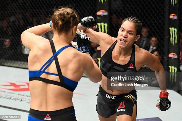Amanda Nunes of Brazil punches Ronda Rousey in their UFC women's bantamweight championship bout during the UFC 207 event at T-Mobile Arena on...