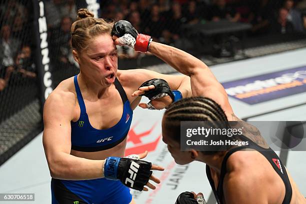 Amanda Nunes of Brazil punches Ronda Rousey in their UFC women's bantamweight championship bout during the UFC 207 event at T-Mobile Arena on...