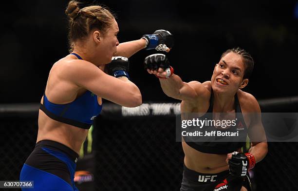 Amanda Nunes of Brazil punches Ronda Rousey in their UFC women's bantamweight championship bout during the UFC 207 event at T-Mobile Arena on...