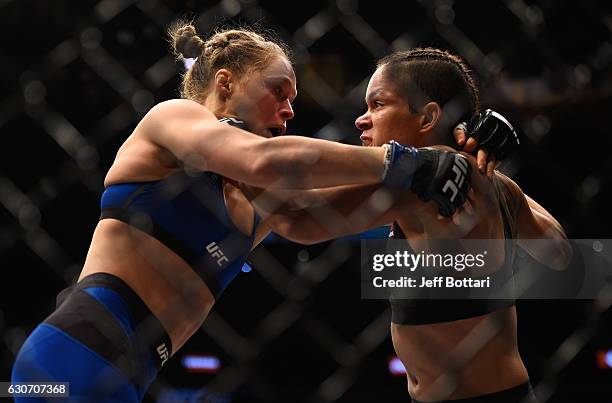 Amanda Nunes of Brazil punches Ronda Rousey in their UFC women's bantamweight championship bout during the UFC 207 event at T-Mobile Arena on...