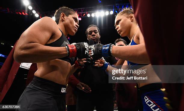 Amanda Nunes of Brazil and Ronda Rousey touch gloves in their UFC women's bantamweight championship bout during the UFC 207 event at T-Mobile Arena...