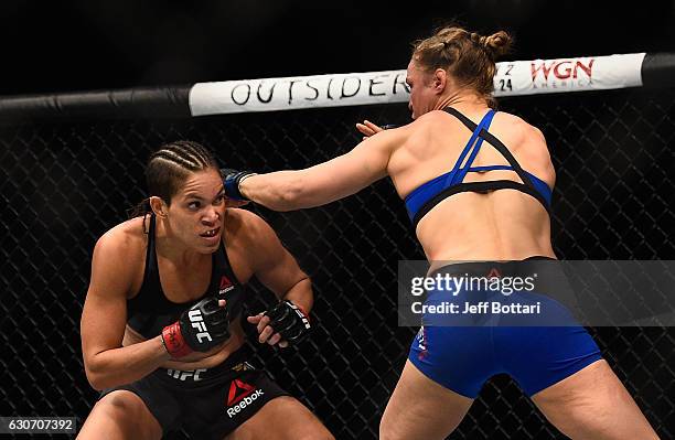 Ronda Rousey punches Amanda Nunes of Brazil in their UFC women's bantamweight championship bout during the UFC 207 event at T-Mobile Arena on...