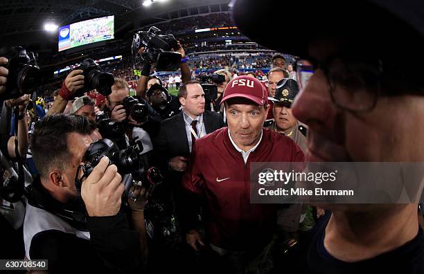 Head coach Jimbo Fisher of the Florida State Seminoles shakes hands with head coach Jim Harbaugh of the Michigan Wolverines after the Seminoles...