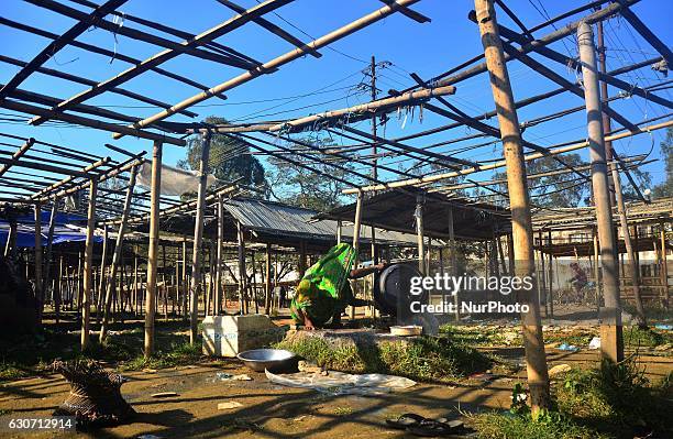 An Indian woman washes clothes in an empty makeshift market on the last day of the year in Dimapur, India north eastern state of Nagaland on...