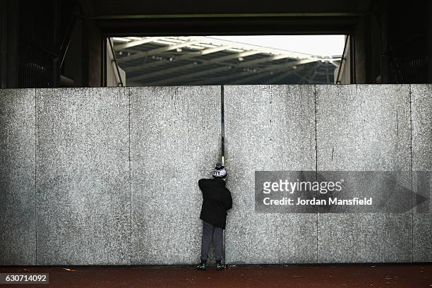 Young Swansea City supporter is seen watching inside the stadium from the gap of the walls prior to the Premier League match between Swansea City and...
