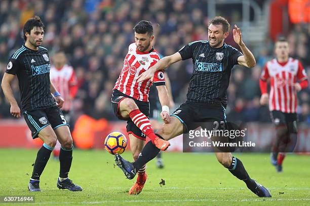Shane Long of Southampton and Gareth McAuley of West Bromwich Albion compete for the ball during the Premier League match between Southampton and...