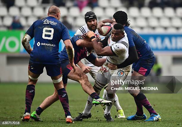 Brive's Fidjiian center Seremaia Burotu is tackled by Stade Francais' French hooker Remi Bonfils and Stade Francais' Australian lock Hugh Pyle during...