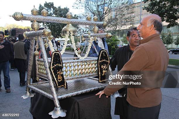 Pakistani Shiite Muslims touch a cradle symbolizing the cradle of Hazrat Ali Asghar , the youngest son of Imam Hussein, during the holy month of...