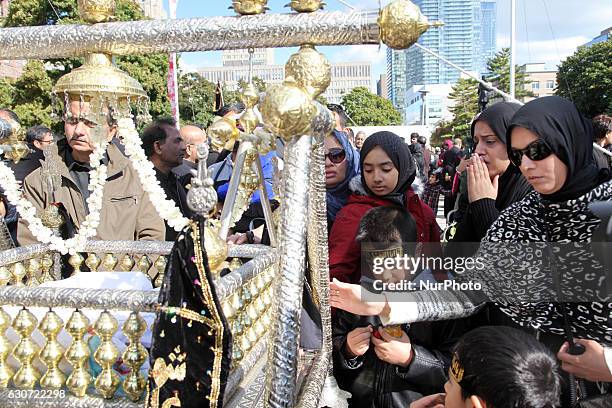 Pakistani Shiite Muslims touch a cradle symbolizing the cradle of Hazrat Ali Asghar , the youngest son of Imam Hussein, during the holy month of...