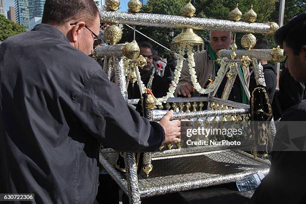 Pakistani Shiite Muslims touch a cradle symbolizing the cradle of Hazrat Ali Asghar , the youngest son of Imam Hussein, during the holy month of...