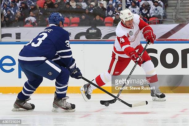 Brendan Shanahan fires a shot at the net as Al Iafrate tries to block it as the Toronto Maple Leafs alumni play the Detroit Red Wings alumni on the...