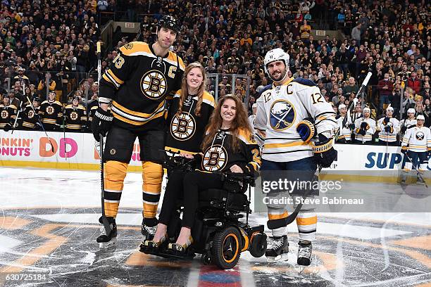 Denna Laing, former hockey player who got injured a year ago today poses with her sister, Zdeno Chara of the Boston Bruins and Brian Gionta the...