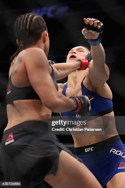 Amanda Nunes of Brazil and Ronda Rousey face off in their UFC women's bantamweight championship bout during the UFC 207 event at T-Mobile Arena on...