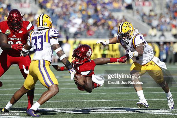 Duke Riley and Jamal Adams of the LSU Tigers chase down Lamar Jackson of the Louisville Cardinals in the third quarter of the Buffalo Wild Wings...