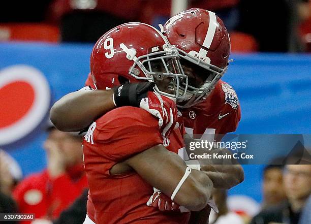 Bo Scarbrough of the Alabama Crimson Tide and Cam Robinson of the Alabama Crimson Tide celebrate after a touchdown during the 2016 Chick-fil-A Peach...