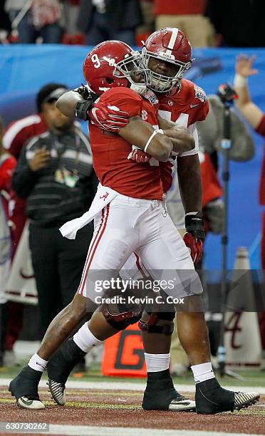 Bo Scarbrough of the Alabama Crimson Tide and Cam Robinson of the Alabama Crimson Tide celebrate after a touchdown during the 2016 Chick-fil-A Peach...