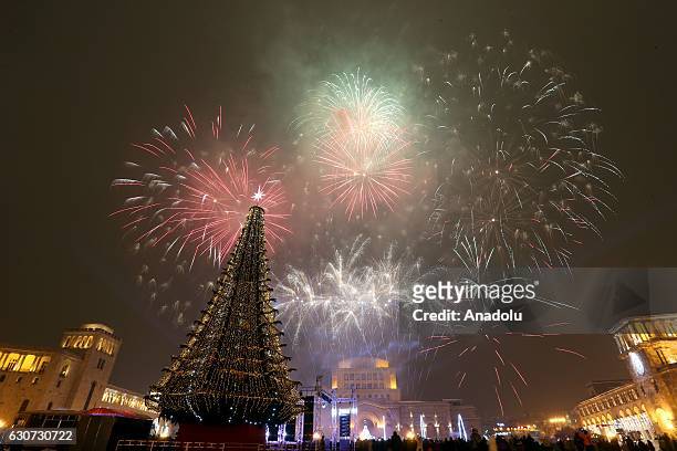 Fireworks light up near the main Christmas tree, at the Republic Square during the New Year's Eve celebrations in Yerevan, Armenia on December 31,...
