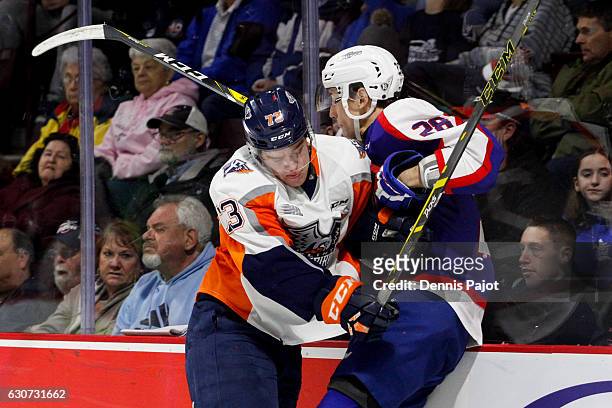 Forward Jacob Collins of the Flint Firebirds places a hit against defenceman Tyler Nother of the Windsor Spitfires on December 31, 2016 at the WFCU...