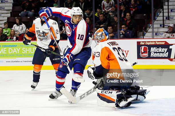 Forward Jeremiah Addison of the Windsor Spitfires moves the puck against goaltender Garrett Forrest of the Flint Firebirds on December 31, 2016 at...