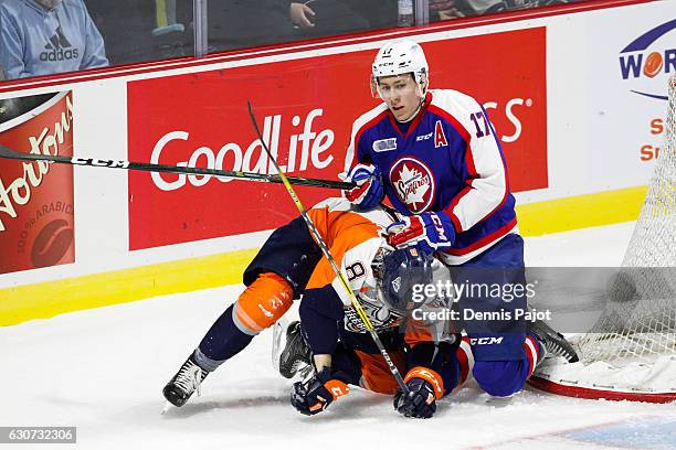 Defenceman Logan Stanley of the Windsor Spitfires battles against forward Dane Johnstone of the Flint Firebirds on December 31, 2016 at the WFCU...