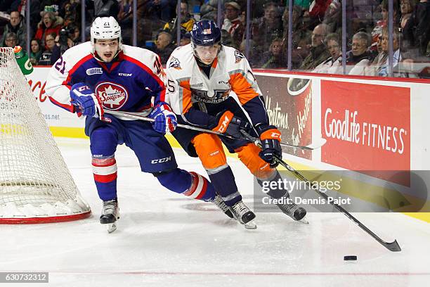 Defenceman Fedor Gordeev of the Flint Firebirds moves the puck against forward Logan Brown of the Windsor Spitfires on December 31, 2016 at the WFCU...