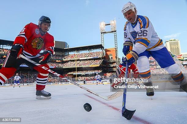 Steve Poapst of the Chicago Blackhawks and Peter Stastny of the St. Louis Blues chase the puck during the 2017 NHL Winter Classic Alumni Game at...