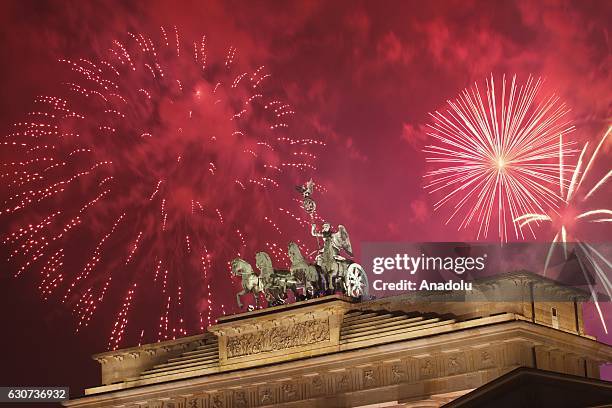Fireworks light the sky over the Quadriga statue a top the Brandenburg Gate during the New Year's celebrations in Berlin, Germany on January 01, 2017.