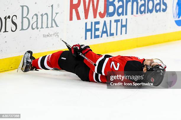 New Jersey Devils defenseman John Moore lies motionless on the ice after getting hit into the boards by Washington Capitals right wing Tom Wilson...