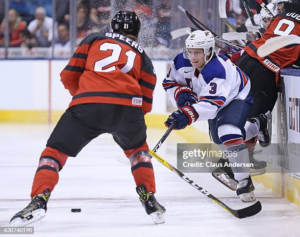 Jack Ahcan of Team USA passes a puck in front of Blake Speers of Team Canada during a preliminary round game in the 2017 IIHF World Junior Hockey...