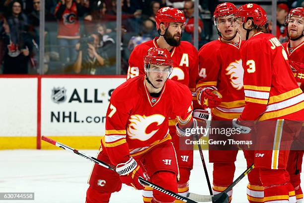 Lance Bouma, Jyrki Jokipakke and teammates of the Calgary Flames celebrate a goal against the Arizona Coyotes during an NHL game on December 31, 2016...