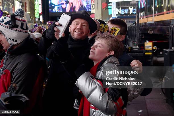 Donnie Wahlberg and Evan Joseph Asher pose for selfies during Dick Clark's New Year's Rockin' Eve 2017 at Times Square on December 31, 2016 in New...