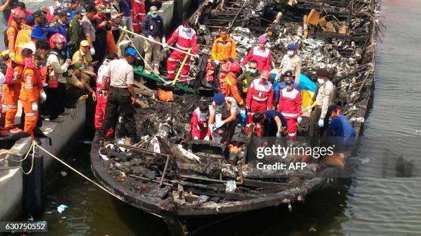 Rescuers search the charred passenger boat which was ferrying around 200 people off the coast of Jakarta to Tidung island, a tourist destination 50...