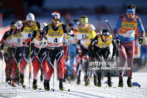 Sergey Ustiugov of Russia and Martin Johnsrud Sundby of Norway lead the pack of the men's 10 km mass start race at the FIS cross country Tour De Ski...