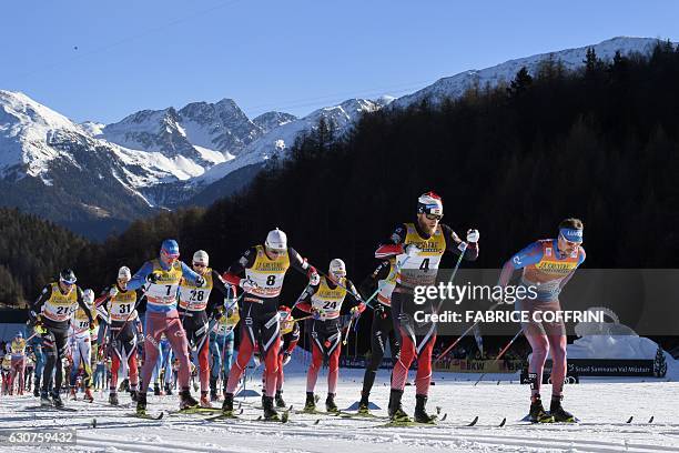 Sergey Ustiugov of Russia and Martin Johnsrud Sundby of Norway lead the pack of the men's 10 km mass start race at the FIS cross country Tour De Ski...
