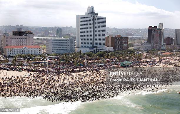 General view shows thousands of New Year's day revellers and holidaymakers gathering on North Pier Beach during New Year festivities in Durban on...