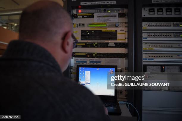 Worker checks on a computer the control panel at the TDF radiobroadcaster building in Allouis near Vierzon, central France, on December 23 after...
