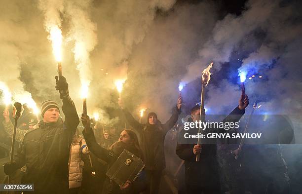 People hold torches and smoke bombs during a march in Kiev on January 1 to mark the 108th anniversary of the birth of Ukrainian politician Stepan...