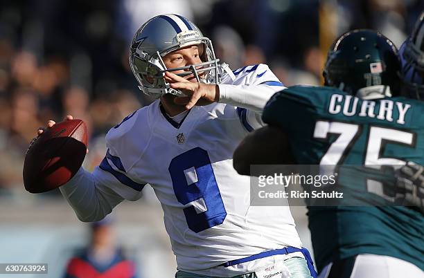 Quarterback Tony Romo of the Dallas Cowboys attempts his first pass of the season as Vinny Curry of the Philadelphia Eagles closes in during the...