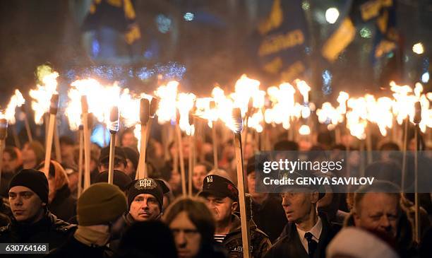 People hold torches during a march in Kiev on January 1 to mark the 108th anniversary of the birth of Ukrainian politician Stepan Bandera, one of the...