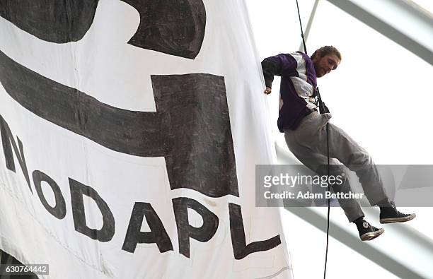 Protestor of the Dakota Access Pipeline hangs by a harness from the rafters during the second quarter of the Minnesota Vikings and Chicago Bears game...