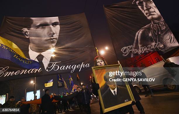 People hold flags picturing Ukrainian politician Stepan Bandera , one of the leaders of Ukrainian national movement and leader of the Organisation of...