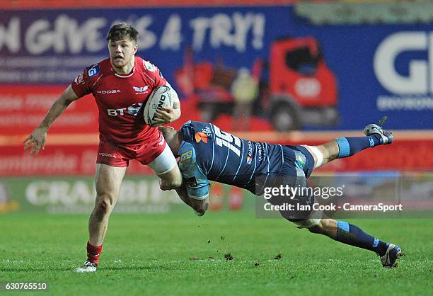 Scarlets' Steffan Evans is tackled by Cardiff Blues' Jarrad Hoeata during the Guinness PRO12 Round 12 match between Scarlets and Cardiff Blues at...