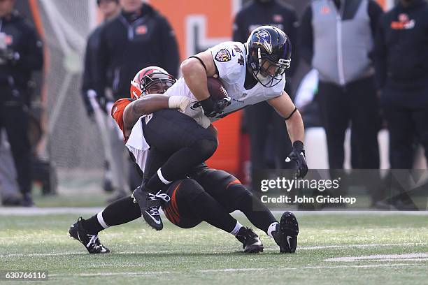 Vincent Rey of the Cincinnati Bengals tackles Kyle Juszczyk of the Baltimore Ravens during the second quarter at Paul Brown Stadium on January 1,...